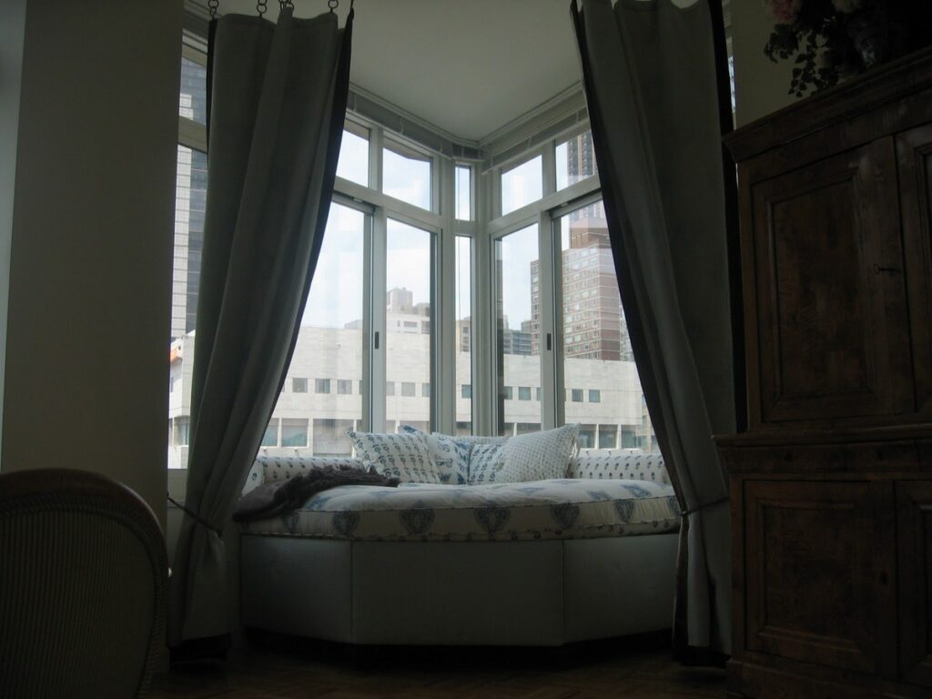 Cozy corner window seating nook with panoramic city views