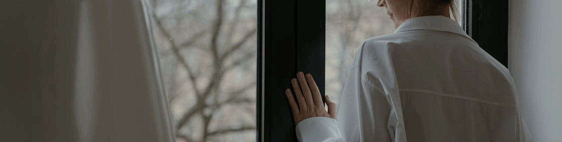 An Elderly Woman Looking through the Window