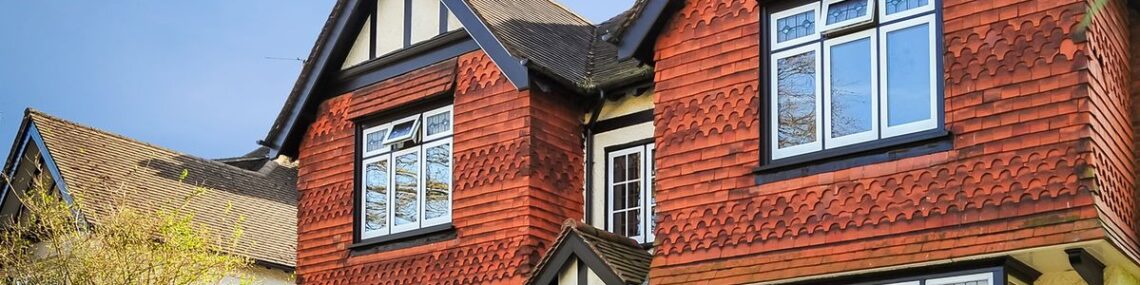 Traditional two story home featuring white replacement windows and gables