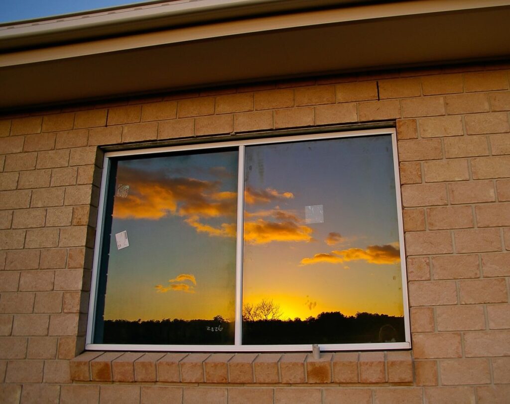 Sunset sky beautifully reflected in exterior sliding house window