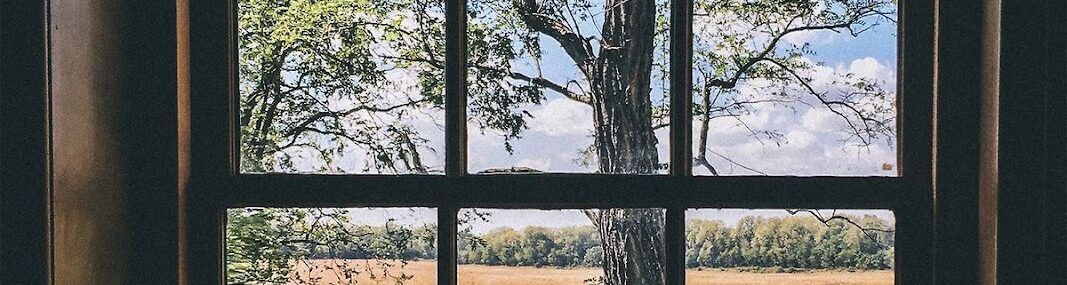 Scenic countryside landscape viewed through classic multi pane window