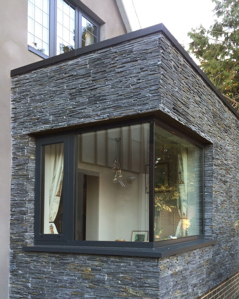Modern stone exterior with large corner window design
