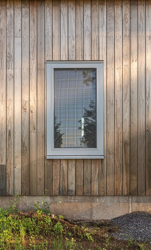 Modern energy efficient window installed in natural wood exterior siding