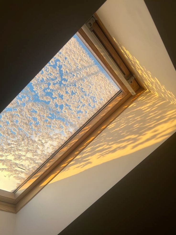 Snow covered skylight letting warm sunlight create glowing shadows inside