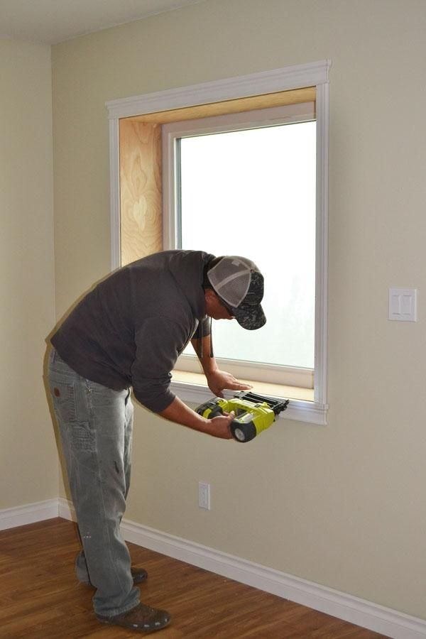 Contractor installing new interior window trim during home renovation